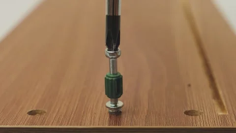 Human hands use a screwdriver to screw in the screws and assemble furniture.. Stock Footage 340474701