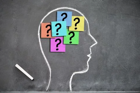 Human head shape on a blackboard with question marks on post-its inside Fotos Stock