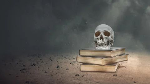 Human head skull on a stack of books on the field with a dark background. T.. Stock Photos