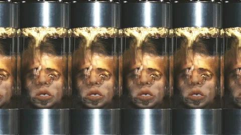 Human heads without a body in cylindrical glass vessels (flasks), in a liquid Stock Footage 122595747