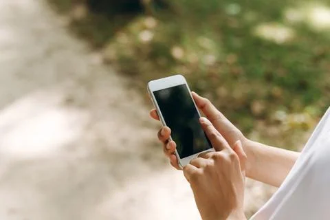 A human is holding the phone while walking. Stock Photos