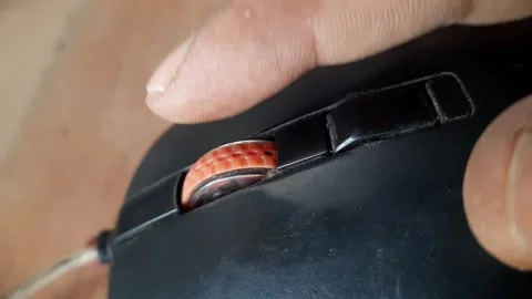Human index finger scrolling an orange scroll wheel on a black computer mou.. Stock Footage 324825310