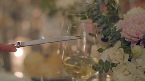 Human knocks on a glass with a knife, attracting attention to make a toast Stock Footage 129671229
