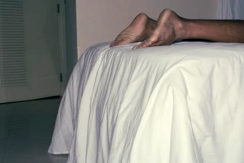 Human legs on bed Stock Photos