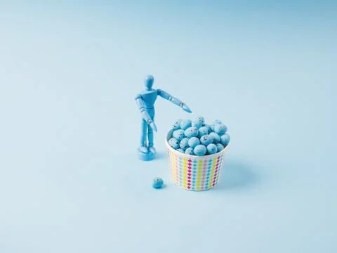 Human marionette and easter eggs on blue Stock Photos