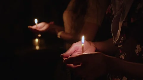 Human palm hands holding burning candle in dark black background. Close up view Stock Footage 253556824