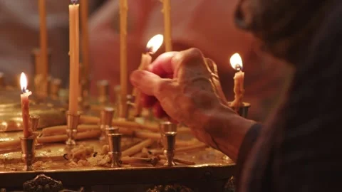 Human palm hands holding burning candle in dark black background. Close up view 스톡 동영상 253773826