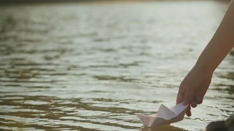 Human put paper ship boat on water in the park close up. Origami paper crane on Stock Footage 260415192