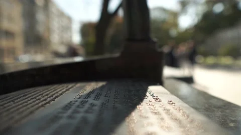 Human reads text written in Braille font sunny day street board. People on Stock Footage 178883287