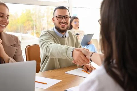 Human resources manager shaking hands with applicant during job interview in  Foto stock