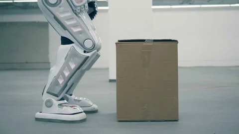 Human-like robot is lifting a box and carrying it Stock Footage 101979423