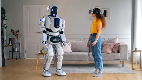Human-like robot is touching a hand of a lady in VR-glasses. Smart home concept. Stock Footage 115635315