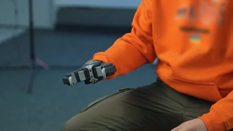 A human with a robotic arm demonstrates 360-degree rotation, extension, and Stock Footage 264540396