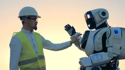 Human-like robot's setting are being regulated by an engineer in a hardhat Vídeo Stock 97997538