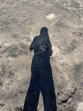 Human Shadow on Sandy Beach in Natural Sunlight Stock Photos