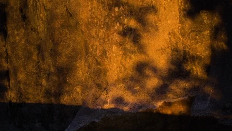Human shadows running on sunset rock wall in slowmotion Video stock 87759471