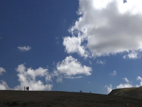 Human silhouettes fluffy clouds dog mountains Stock Footage 70960148