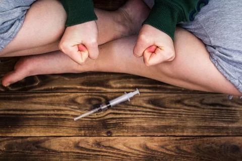 Human sitting in front of syringe Foto stock