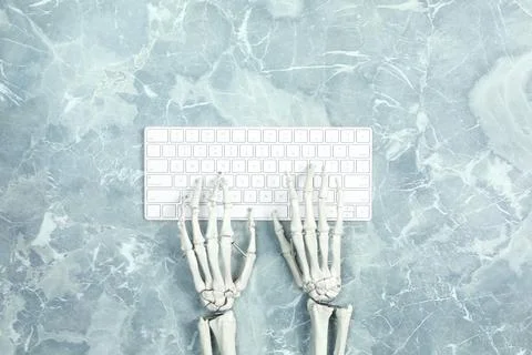 Human skeleton using computer keyboard at grey marble table, top view Stock Photos