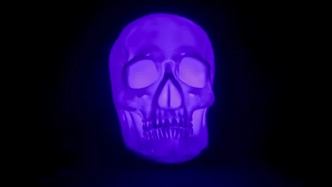Human Skull glowing different colors against black backdrop Stock Footage 250465396