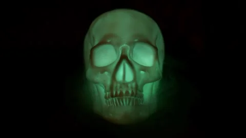 Human skull glowing different colors on black backdrop. Stock Footage 250465517