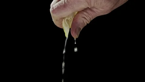 Human squeezes lemon as fresh lemon juice pours in his hand. squeezing a le.. Stock Footage 265839270