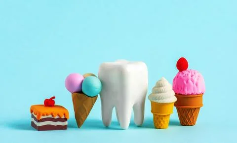Human tooth model with tiny sweets. Unhealthy sweet food cases caries concept Stock-Fotos
