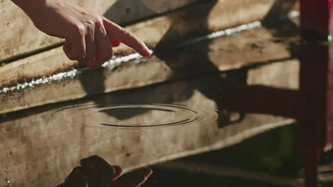 Human touch water with his finger. Female's arm splashing in the pond.Nice view Stock Footage 254433700
