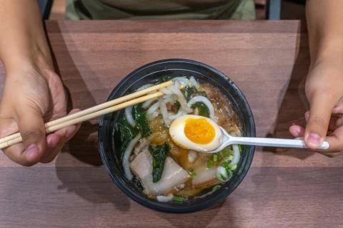 Human using chopsticks while eating Japanese Udon noodles soup Stock Photos