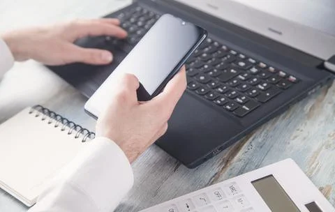 Human using smartphone and working on computer. Stock Photos