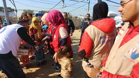 Humanitarian worker giving candy to refugee kids Stock-Footage 96032914