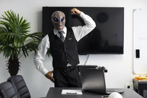 A humanoid Alien in a white shirt and business suit flexing one hand biceps,  Stock Photos