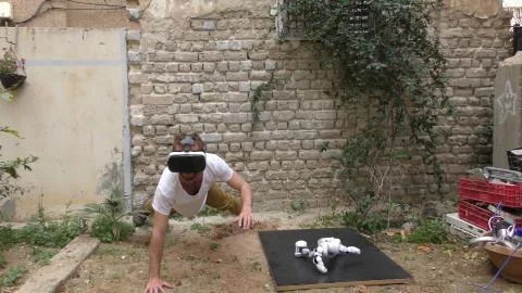 A humanoid android robot and a young man exercise push ups Stock Photos