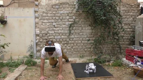 A humanoid android robot and a young man exercise push ups Stock Photos