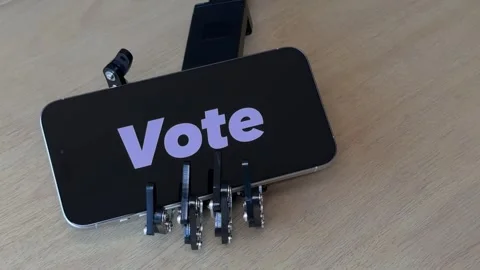 Humanoid Robot Hand Holding Smartphone with Vote Text Stock Footage 280009726