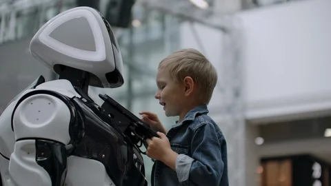 Humanoid robot talks with child at technology exhibition. The Exhibition Park Of Stock Footage 114904102