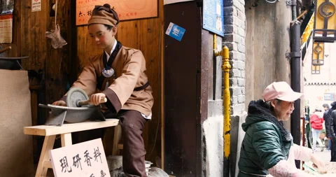 Humanoid robot of young man in ancient Chinese dress grinding spices Stock Footage 124459380