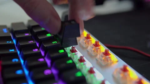 A human's hand assembles the keys of a mechanical keyboard with red switches Stock Footage 194561329