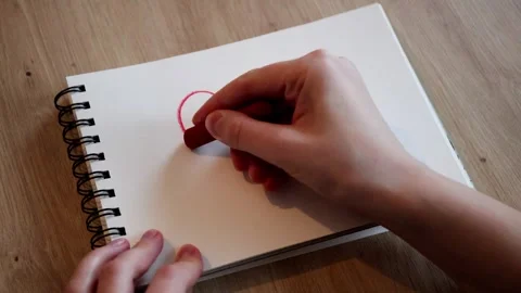 A human's hand drawing a red heart on a sketchbook. Valentines day Stock Footage 326643698