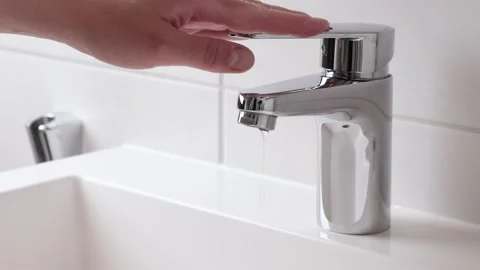 Human's hand stops leaking water tap with dripping waterdrop Stock Footage 277328587
