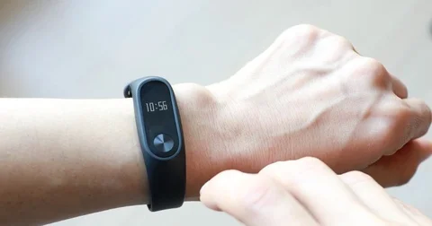 Human's hand touching screen pad of wristband to look at clock and step counter Stock Footage 73309103