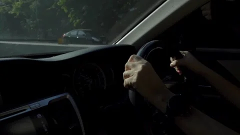 Human's hands on the steering wheel, inside the car. Taken in close-up, in the Stock-Footage 336266010