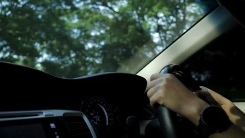 Human's hands on the steering wheel, inside the car. Taken in close-up, in the Stock-Footage 336266088
