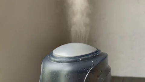 Humidifier works on the grey wall backgound. Water mist steam from humidifier. Stock Footage
