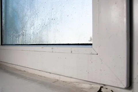 From the humidity and dampness on the window, the paint flakes off on the w.. Stock Photos