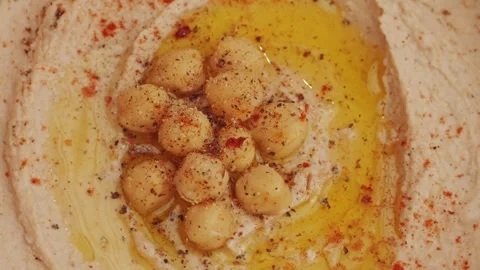 Hummus among fresh vegetables on table rotating top view. Pouring vegetables Stock Footage 266960140