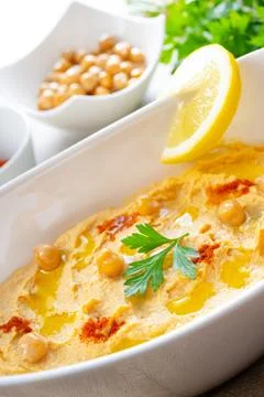 Hummus paste with lemon and chilli on white background Stock Photos
