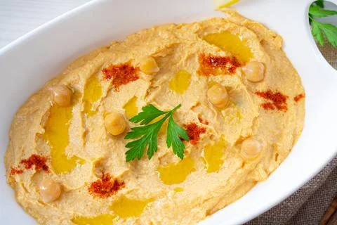 Hummus paste with lemon and chilli on white background Stock Photos
