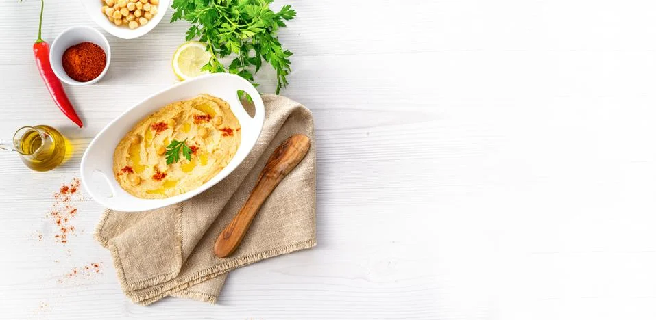 Hummus paste with lemon and chilli on white background Stock Photos