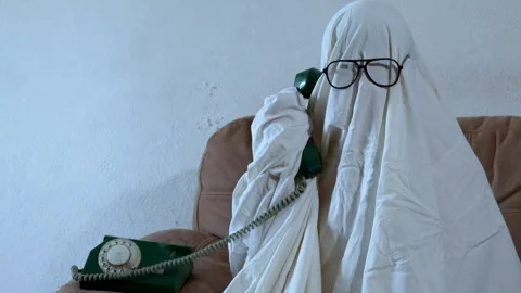 A humorous scene featuring a person dressed as a ghost with a white sheet a.. Stock Footage 314747540